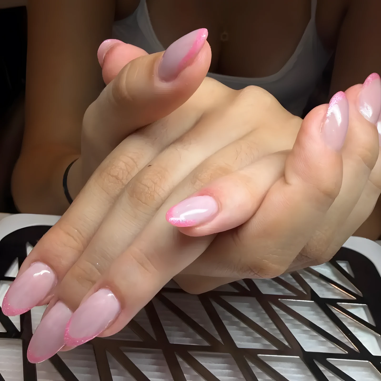 Mani con unghie a mandorla in acrygel, base rosa trasparente e punta glitter